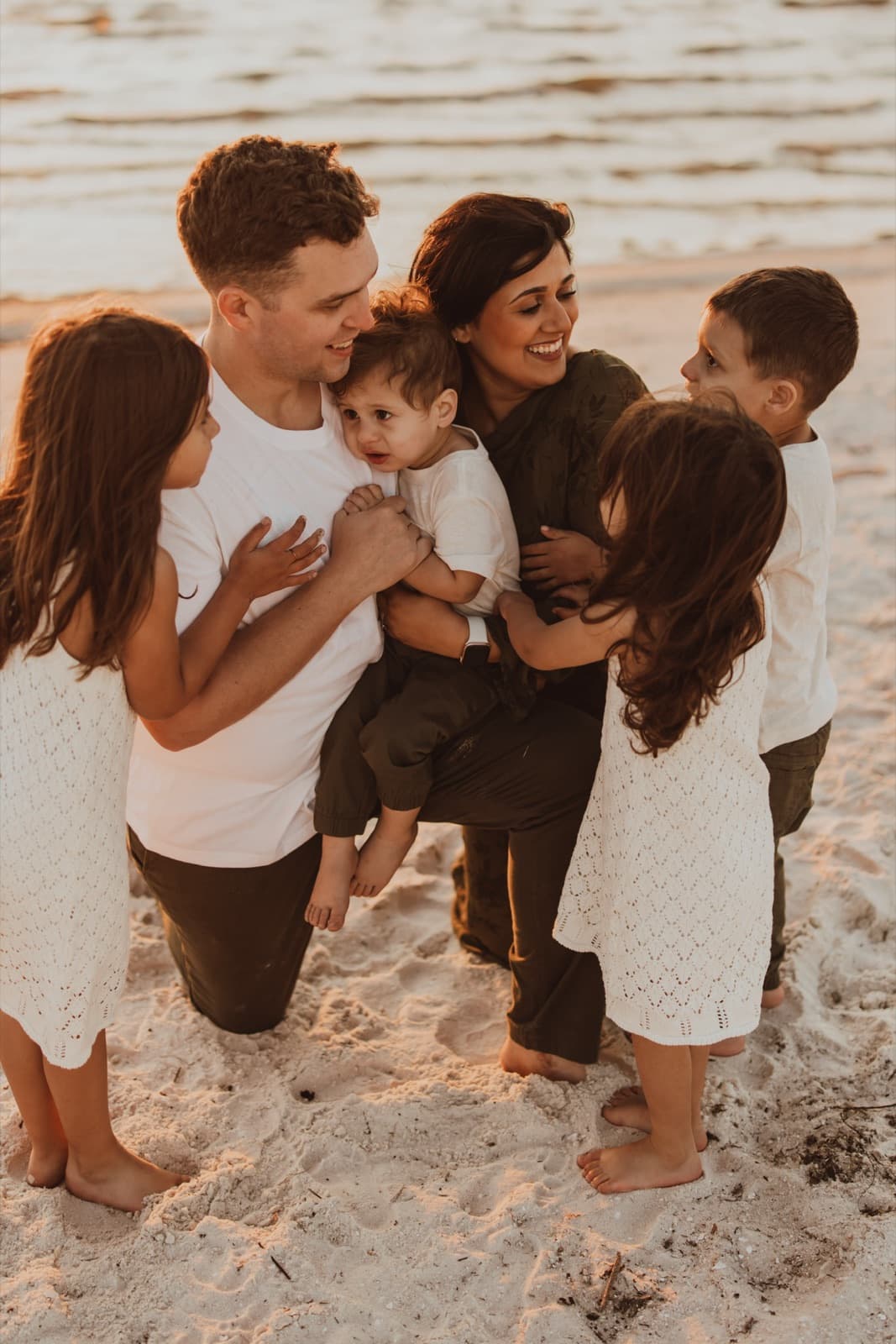 Fatima's family hugging on the beach at sunset