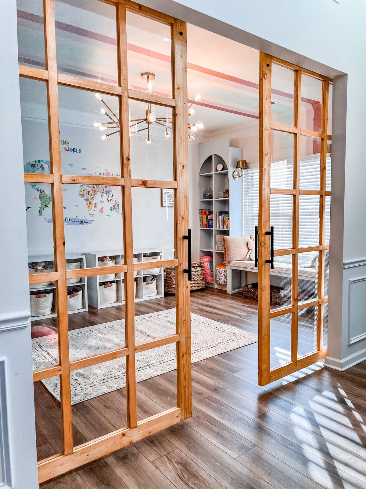 Handmade wood-framed glass doors opening into a playroom